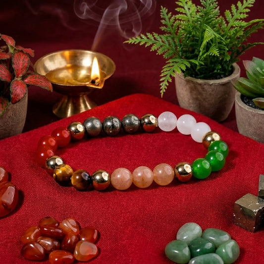Colorful beaded bracelet on a red surface with stones and a small lamp in the background