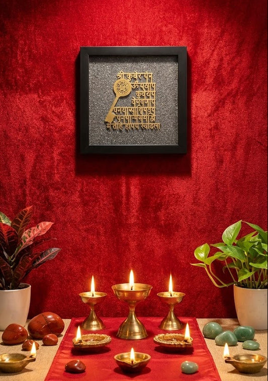 Decorative setup with candles, bowls, and a framed text piece on a red wall.