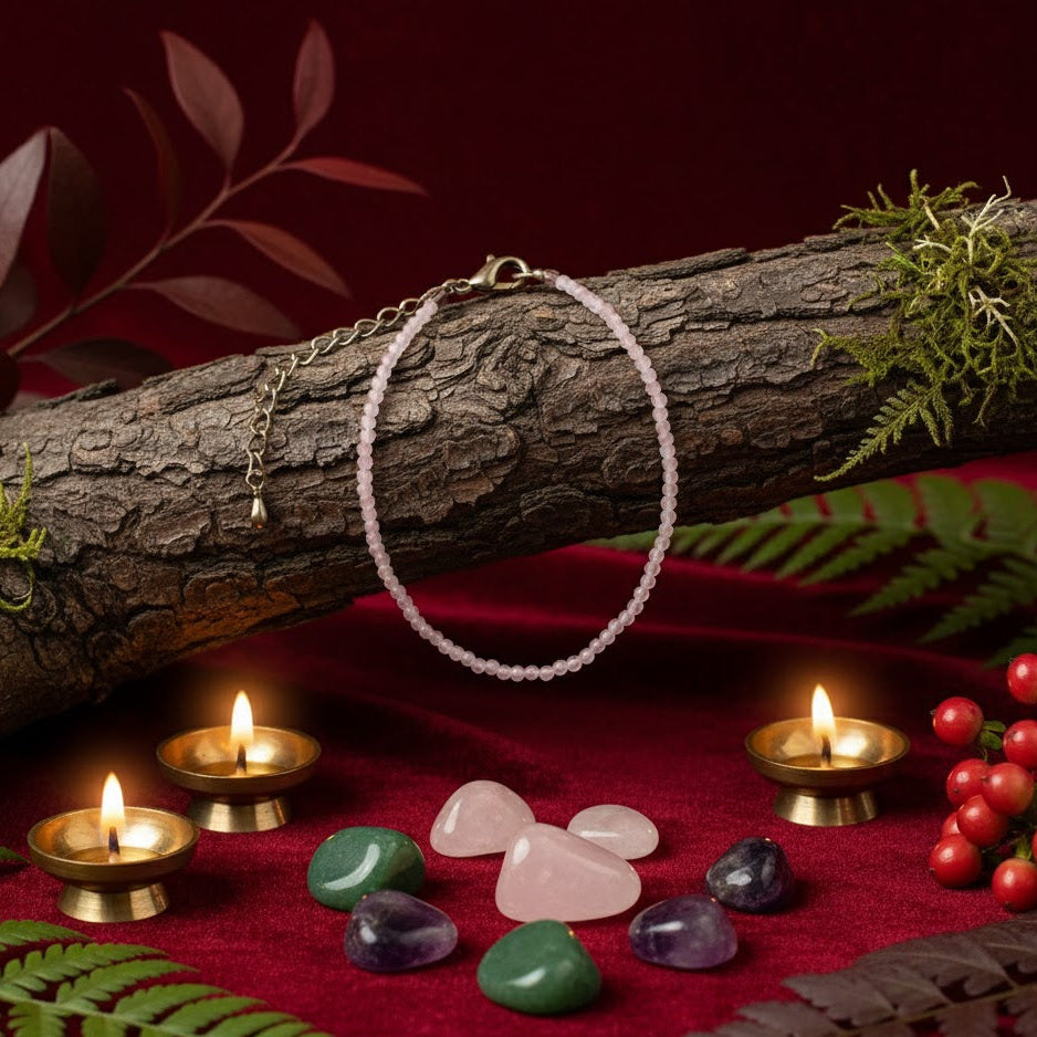 Necklace on a log with candles, stones, and berries on a red surface