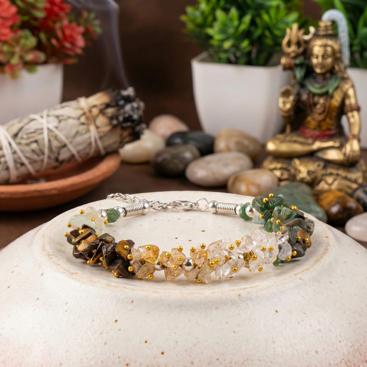 Bracelet with natural stones on a decorative plate with a blurred background of plants and stones.