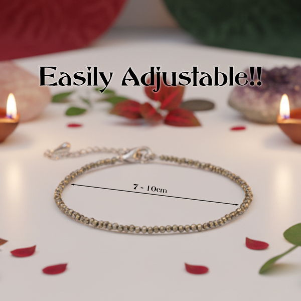 Silver bracelet with adjustable length measurement on a decorative background with candles and flowers.