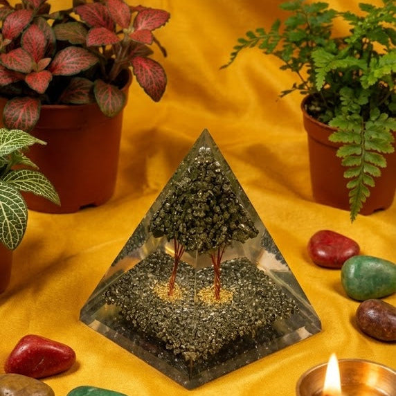 Pyramid with pebbles, candles, and plants on a yellow fabric background
