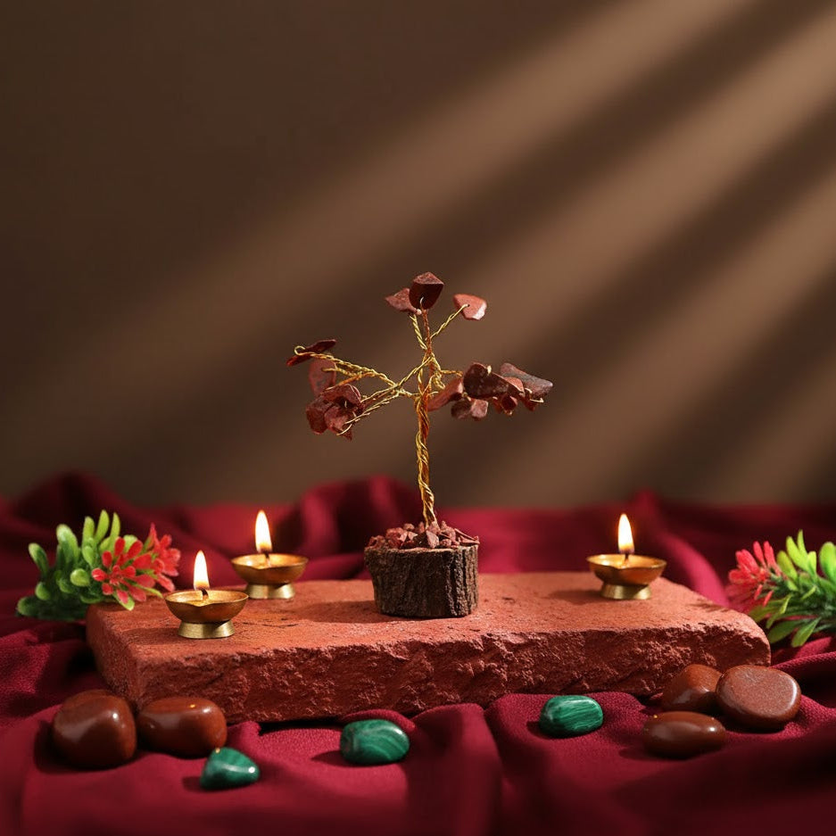 Decorative setup with a small tree, candles, and stones on a red fabric background