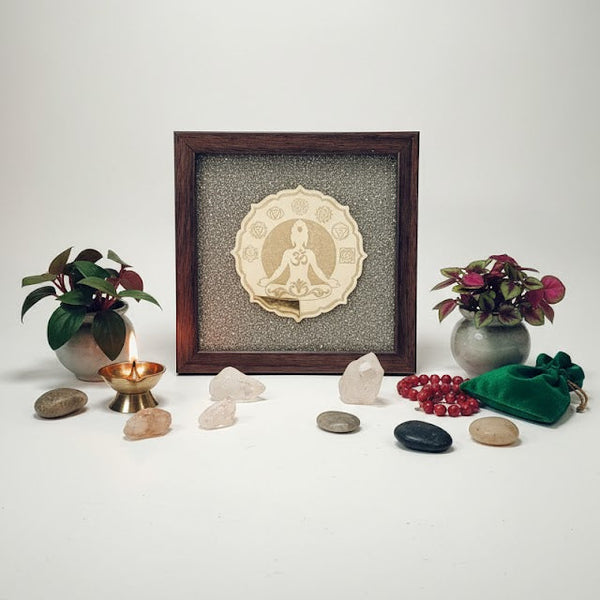 Decorative setup with framed artwork, stones, and plants on a white background