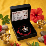 Jewelry set with pendant and red cord in a black box on a yellow background with flowers and stones.