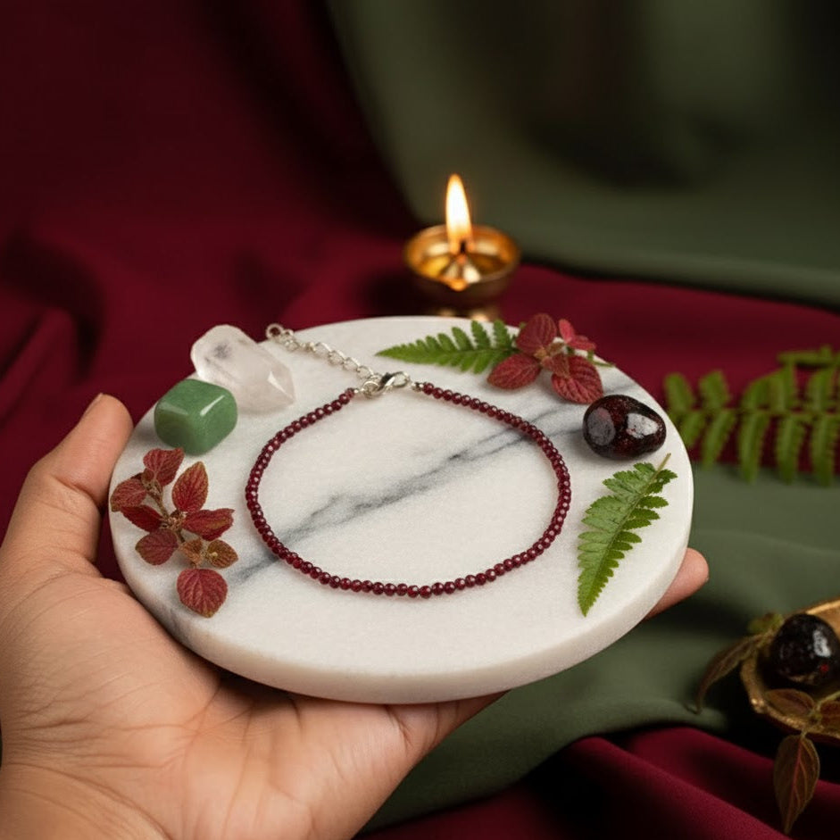 Hand holding a marble tray with decorative elements and a lit candle in the background