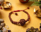 Bracelet made of wood beads on a yellow surface with candles and plants
