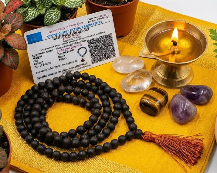 Meditation tools including a mala, crystals, and a candle on a yellow mat with plants around.