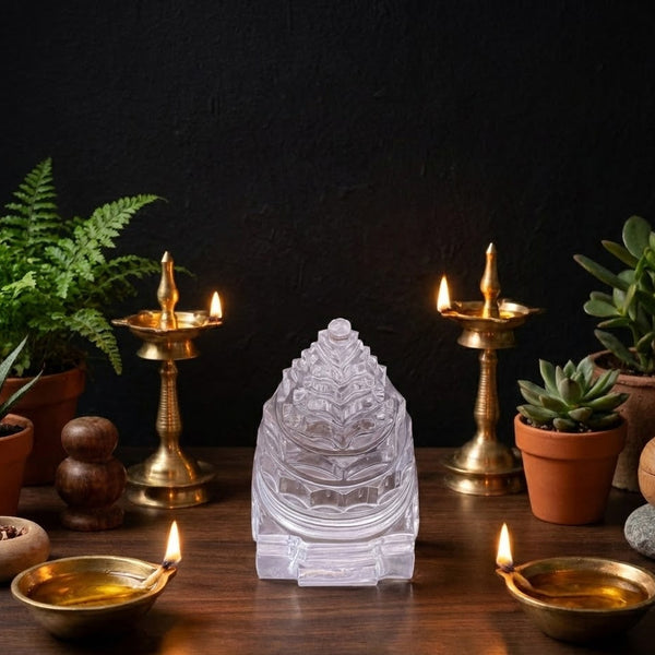 Crystal崇拜物、油灯和盆栽植物在深色背景前的桌子上