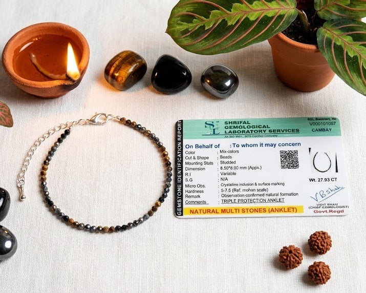 Necklace with stones, a card, and plants on a white surface