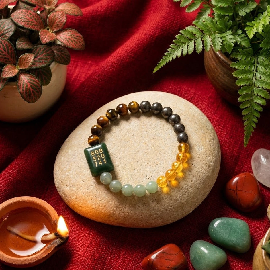 Beaded bracelet on a stone with crystals and a candle on a red fabric background