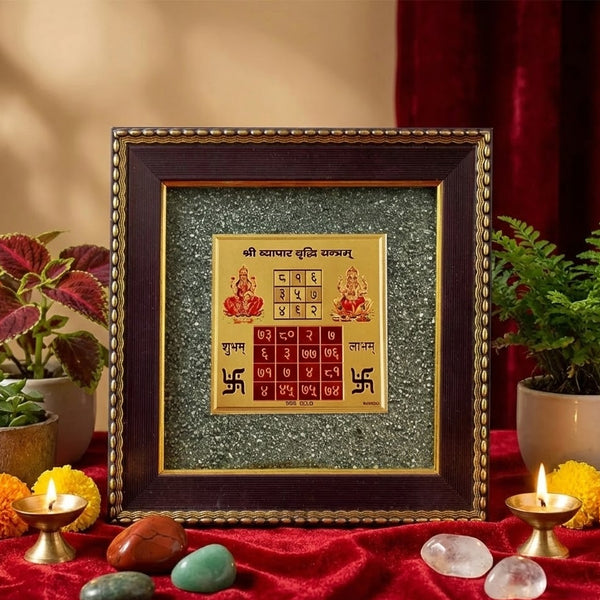 Framed artwork with religious symbols on a red cloth with candles and plants