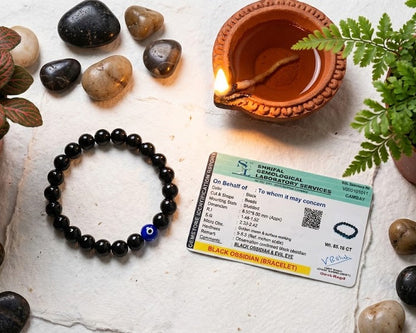 Black beaded bracelet, ID card, and decorative items on a textured surface