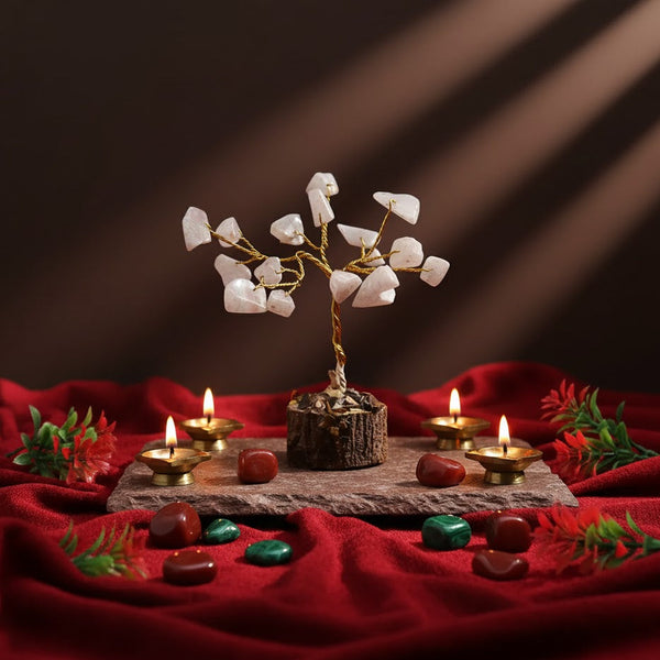 Decorative setup with a small tree, candles, and stones on a red fabric background