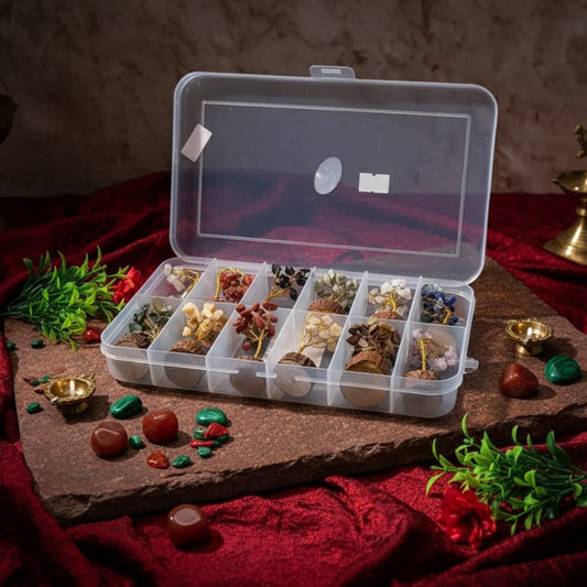 Clear plastic storage box with compartments containing small decorative items on a dark surface.
