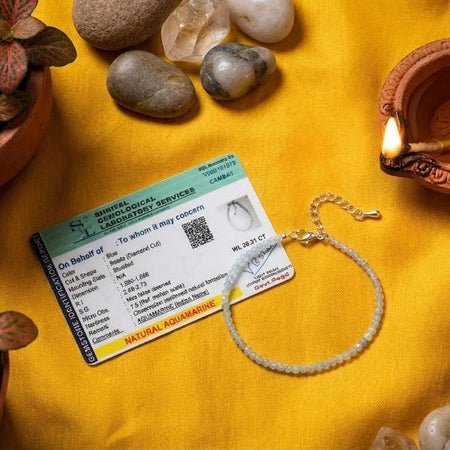 ID card, bracelet, and oil lamp on a yellow fabric background with plants.