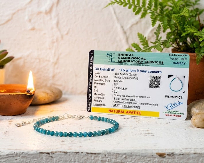 Lab certificate for natural apatite on a decorative surface with plants and a candle.