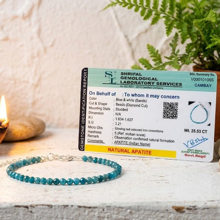 Lab certificate for natural apatite on a decorative surface with plants and a candle.